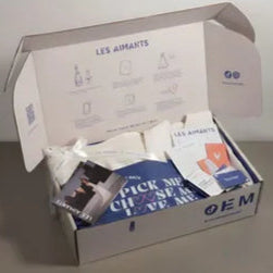 Open box containing various items with visible branding on a gray surface.